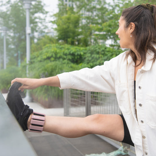 woman stretching with silicone weighted bangle on ankle