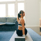 A person is doing yoga on a mat with a Wellrox yoga block