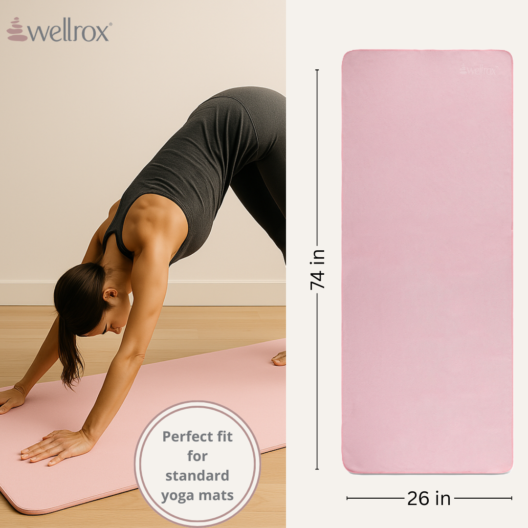 Woman practicing yoga on a pink yoga mat towel with wellrox branding, showing dimensions.