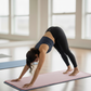 Woman practicing yoga on a wellrox pink mat towel in a yoga studio