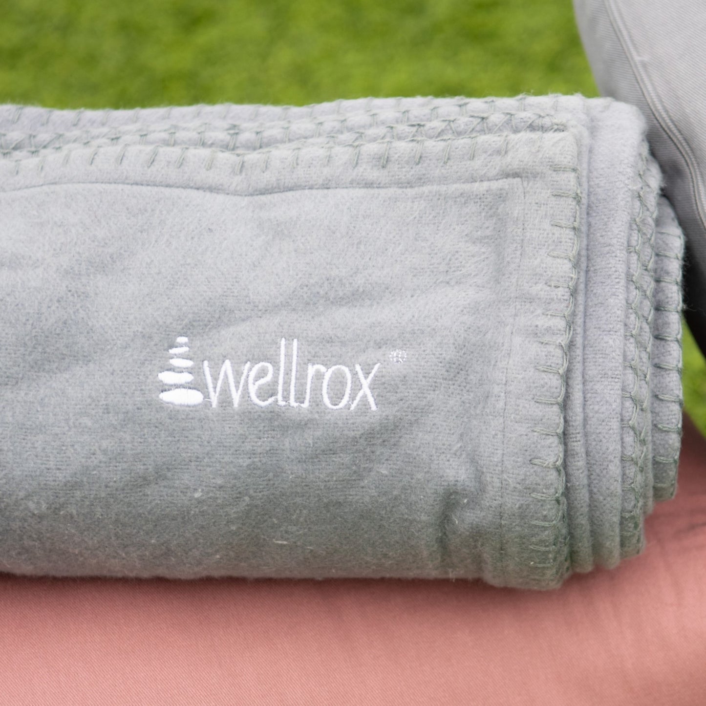 rolled up gray hand-loomed Indian cotton soft machine washable Wellrox yoga blanket, restorative yoga prop