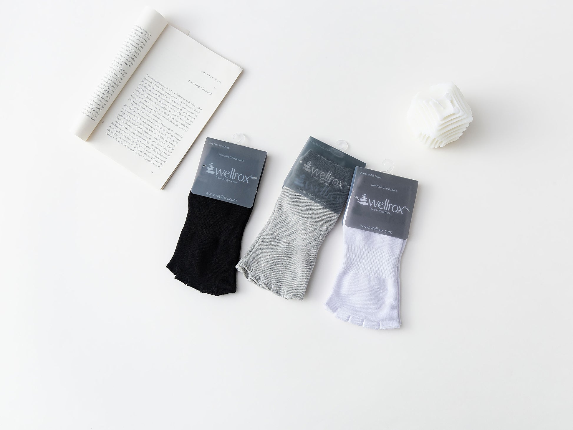 A set of toeless non-slip yoga socks in black, gray, and white colors